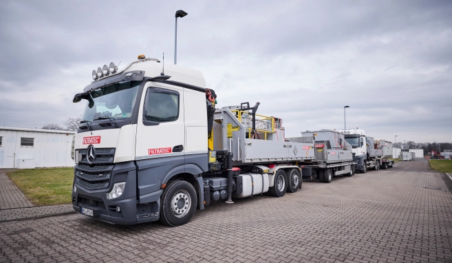 Several FILTRATEC lorries with mobile filter technology parked on a business premises ready to start work.